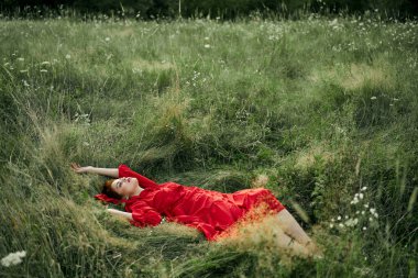 Siyah elbiseli kadın yaz mevsiminde doğa modasında yatıyor.