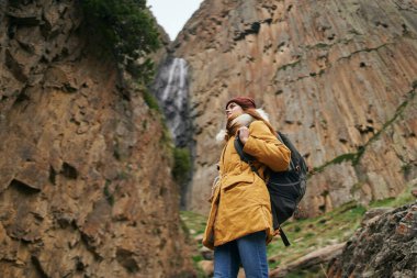 Sırt çantalı kadın yürüyüşçü dağlarda yolculuk özgürlüğü.