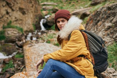 Sırt çantalı kadın yürüyüşçü dağlarda yolculuk özgürlüğü.