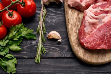 Tahta üzerinde et bifteği. Yemekler üst tarafta.