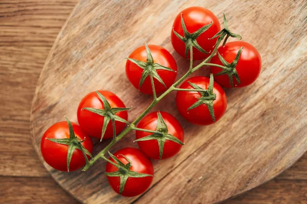 Tomates cherry en una rama en un ingrediente de cocina de tablero de madera alimentos frescos —  Fotos de Stock
