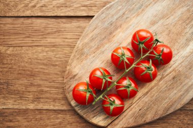 Tahta bir mutfak malzemesinin dalındaki kiraz domatesleri taze gıdalar.