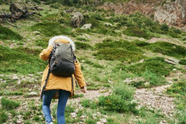 Sırt çantalı kadın yürüyüşçü dağlarda yolculuk özgürlüğü.