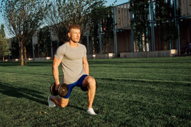 Parktaki adam yeşil çimen egzersiz egzersizi yapıyor.