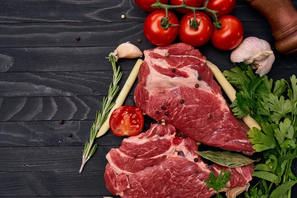 Carne sobre tabla de madera verduras e ingredientes para cocinar fondo de madera — Foto de Stock
