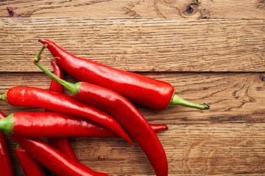 Ahşap mutfak malzemelerinin üzerinde kırmızı kırmızı kırmızı biber.