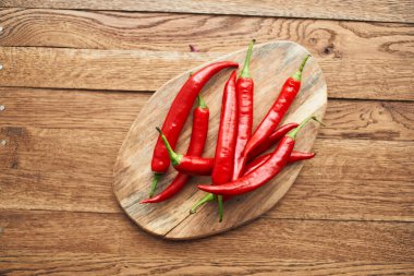 Ahşap mutfak malzemelerinin üzerinde kırmızı kırmızı kırmızı biber.