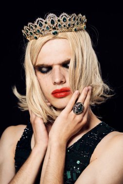 Kadın elbiseli erkek biseksüel pozu veren peruk makyajı.