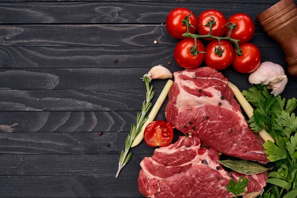 Carne sobre tabla de madera verduras e ingredientes para cocinar fondo de madera — Foto de Stock