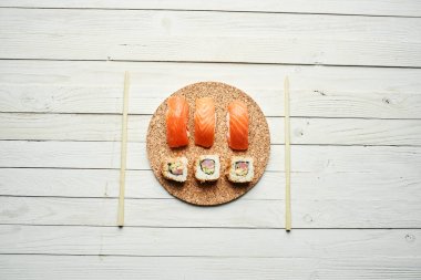 Suşi Japon mutfağını yuvarlıyor. Üst manzara Asya ahşap masa.