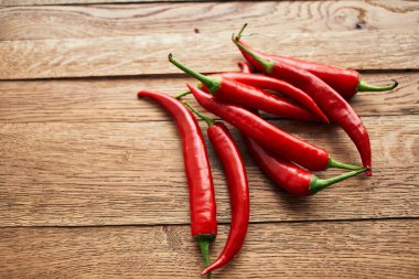Ahşap mutfak malzemelerinin üzerinde kırmızı kırmızı kırmızı biber.