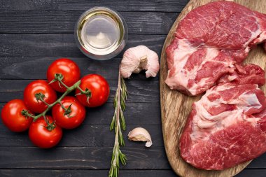 Tahta üzerinde et bifteği. Yemekler üst tarafta.