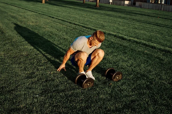 Atletische man in het park workout oefening halters — Stockfoto