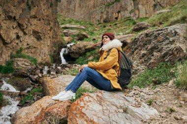 Sırt çantalı kadın yürüyüşçü dağlarda yolculuk özgürlüğü.