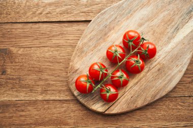 Tahta bir mutfak malzemesinin dalındaki kiraz domatesleri taze gıdalar.