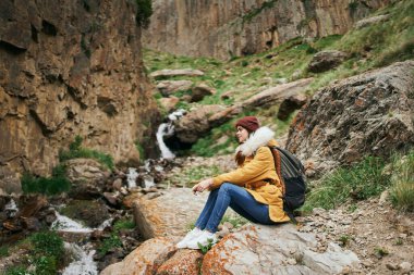 Sırt çantalı kadın yürüyüşçü dağlarda yolculuk özgürlüğü.