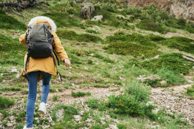Sırt çantalı kadın yürüyüşçü dağlarda yolculuk özgürlüğü.