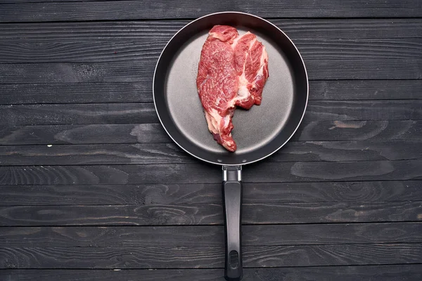 Steak de viande dans une poêle ingrédients cuisine table en bois — Photo