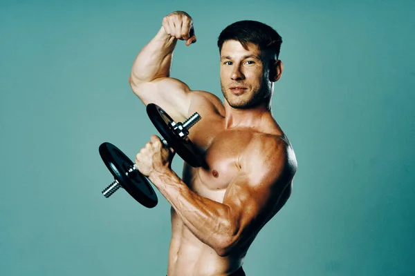 Kulturysta z muskularnym ciałem z hantlami w rękach fitness — Zdjęcie stockowe