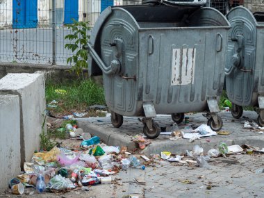 Çimento bloknotuna atılmış iki metal çöp tenekesi. Çevre için çöp sorunu kavramı.
