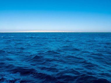 Mavi deniz manzarası, güneş yansıması, açık deniz, mavi gökyüzü ve kıyı şeridi..