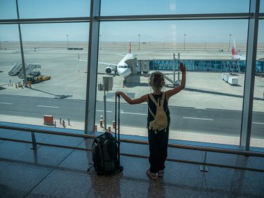 Küçük çocuk hedefe uçuyor. Kalkan uçağa hoşça kal diyor. Boşluğu kopyala.