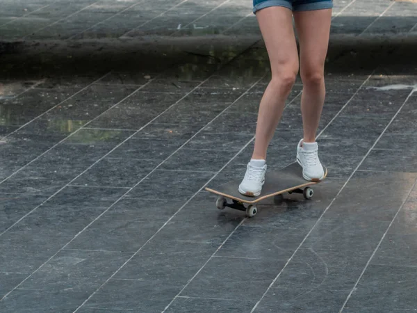Het meisje rijdt op een skateboard. Benen en skateboard close up. — Stockfoto