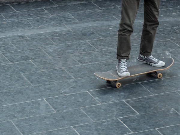 O adolescente vai dar uma volta de skate. Pernas fechadas e skate. — Fotografia de Stock