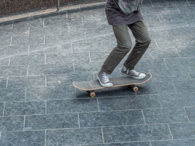 Genç kız kaykayla gezintiye çıkıyor. Yakın bacaklar ve kaykay..