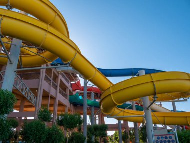 Güneşli bir günde renkli kaydırak ve yüzme havuzu olan güzel bir su parkı manzarası..