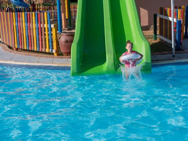 Aquapark 'ta su kaydırağındaki bir çocuk. Yaz tatili.