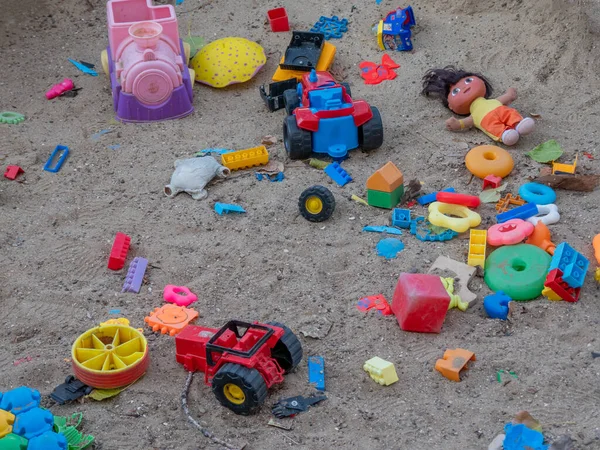 Viele bunte Plastikspielzeuge liegen verstreut auf dem Boden. — Stockfoto