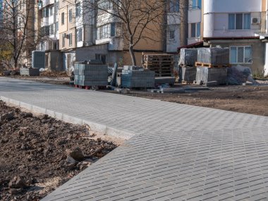 Kaldırımların ve patikaların tamiri. Gri asfalt döşeyen.