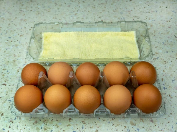 Dez ovos de galinha castanha numa caixa de ovos, de perto. Espaço de cópia. — Fotografia de Stock