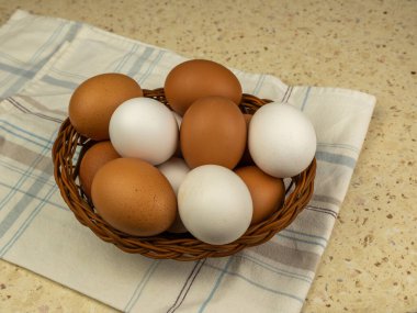 Tahta masada hasır sepetin içinde taze yumurtalar. Yakın plan. Boşluğu kopyala.