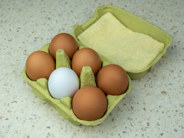 Yeşil bir karton kutuda altı doğal yumurta. Yukarıdan bak. Boşluğu kopyala.