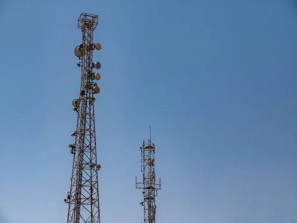 Relay tower with many antennas against the blue sky. — Foto de Stock