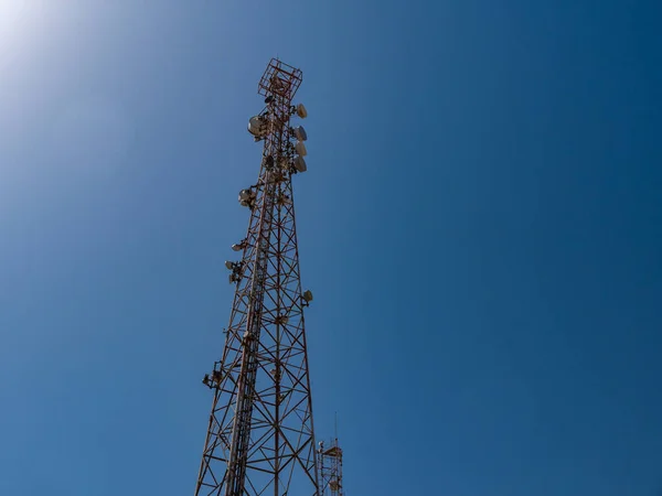 Relay tower with many antennas against the blue sky. — Foto de Stock