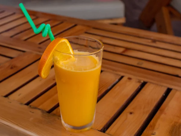 A glass of orange juice with an orange slice and a straw. — Stock Photo, Image
