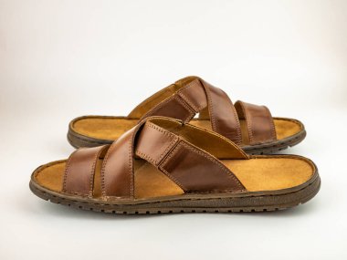 Summer shoes for men.Mens sandals are brown leather flip-flops on a white background.