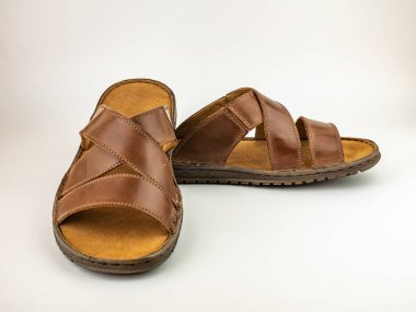 Mens sandals are brown leather flip-flops on a white background. Summer shoes for males. clipart