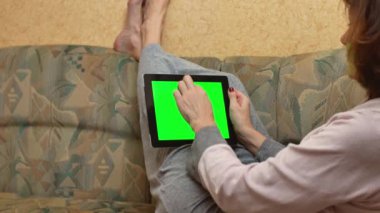 Adult woman working from home at a remote job. Chroma key. Green screen for copy space.