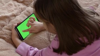 Teenage girl holding tablet computer with green screen. Online learning and education. Chroma key screen.