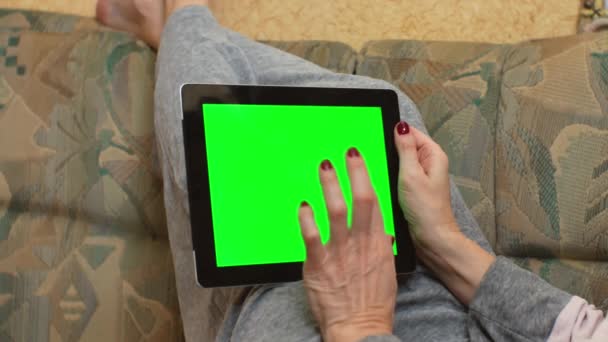 Egy Felnőtt Kezében Egy Tabletta Számítógép Zöld Képernyővel Fekszik Kanapén — Stock videók