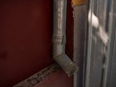 Downspout for draining rainwater from the roof of the house. Iron drain pipe on the wall of the building. Spillway pipe.