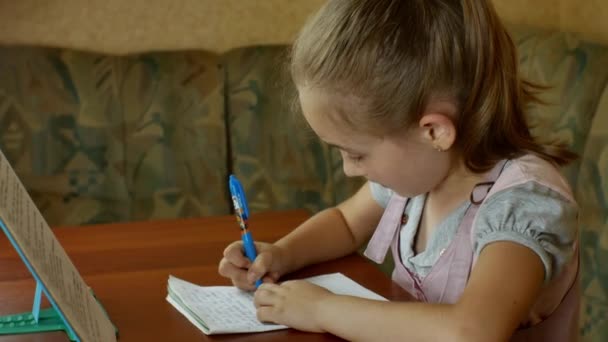 Young Pretty Schoolgirl Doing Her Homework While Sitting Dining Table — Wideo stockowe