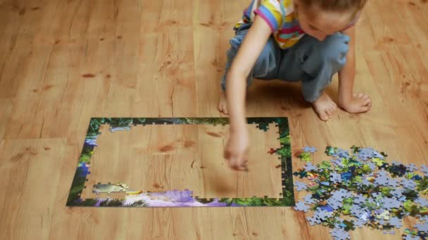 Cute Little Girl Collects Puzzles Sitting Wooden Floor Childrens Leisure — Stockvideo