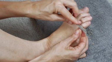 A woman massages her toes after a pedicure. Foot care. The concept of healthy legs. Womens health.