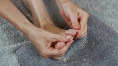 A woman massages her toes after a pedicure. Foot care. The concept of healthy legs. Womens health.