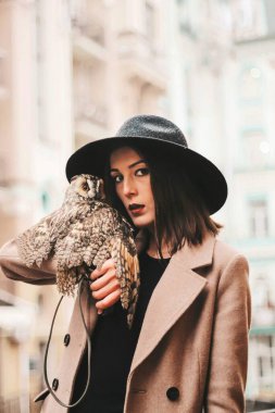 very beautiful girl in a hat with an owl. High quality photo